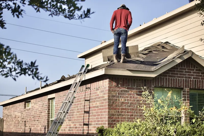 Professional roofer working on a residential roof in Farmersville